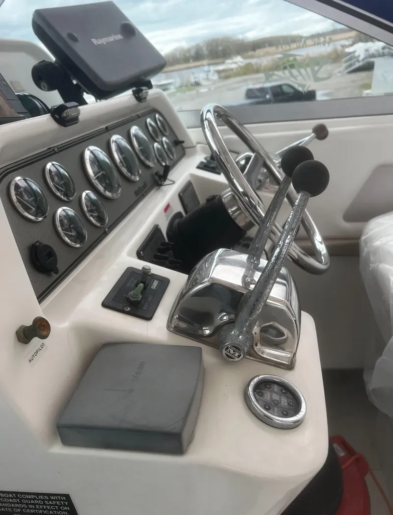 Slide: The Image of Wellcraft 330 Coastal 2000 boat dashboard with steering wheel and control panel. - 7