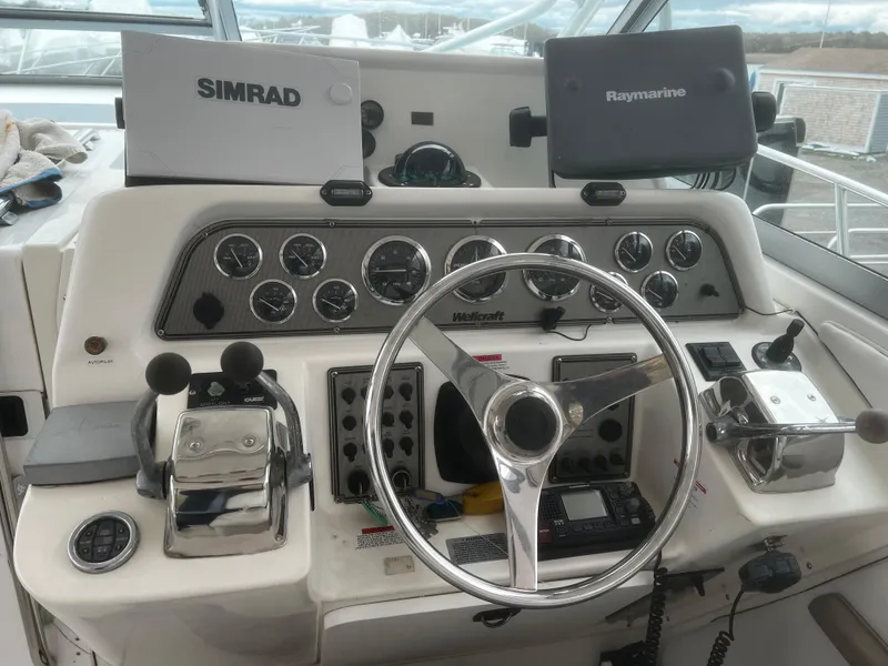 Slide: The Image of Helm of 2000 Wellcraft 330 Coastal with Simrad and Raymarine navigation systems. - 8