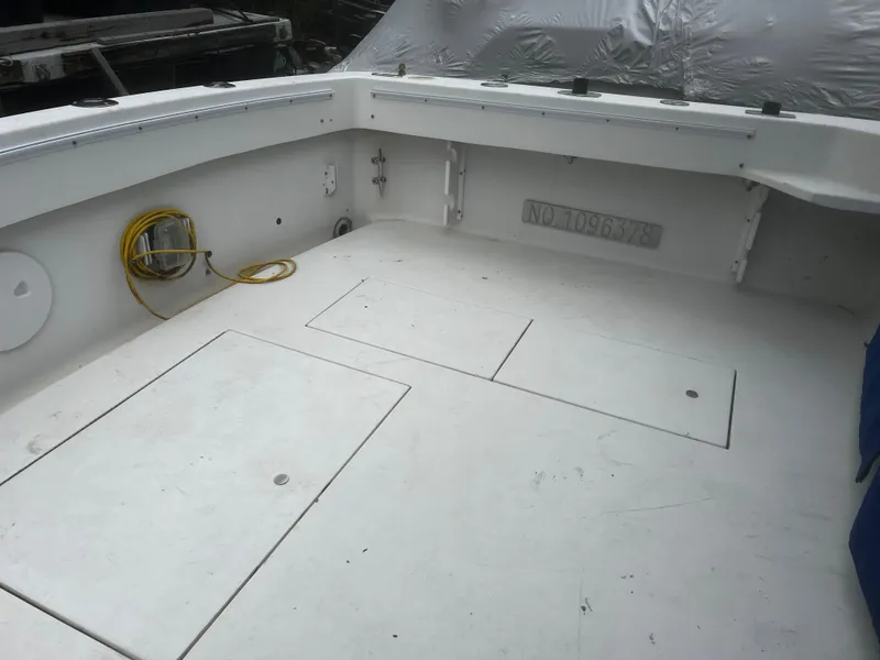 Slide: The Image of 2000 Wellcraft 330 Coastal boat deck with storage compartments and coiled yellow cable. - 9