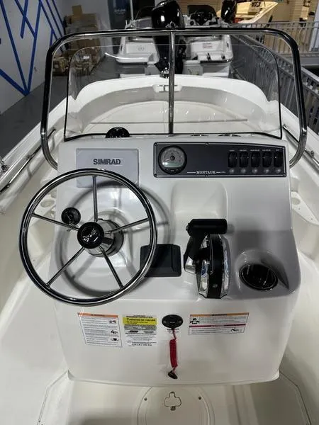Slide: The Image of 2025 Boston Whaler 170 Montauk boat console with steering wheel and controls. - 6