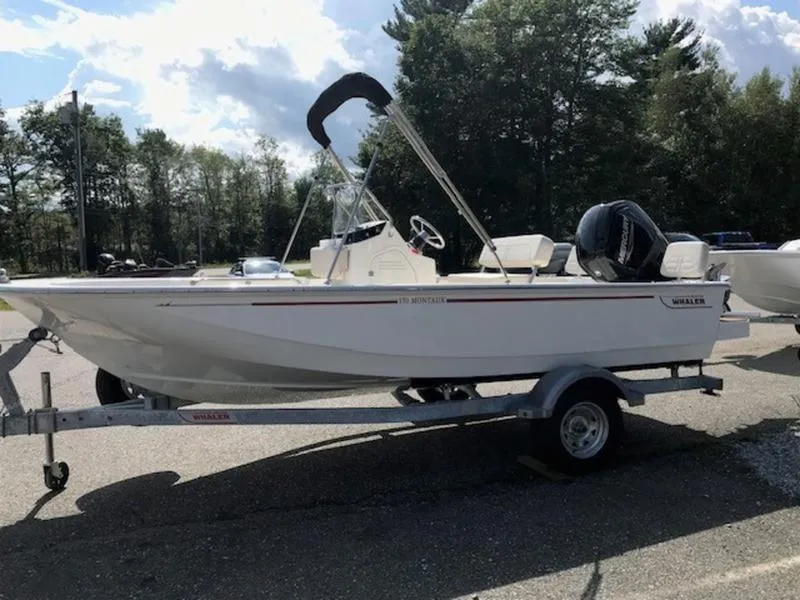 Slide: The Image of 2025 Boston Whaler 170 Montauk boat on trailer, parked outdoors. - 10