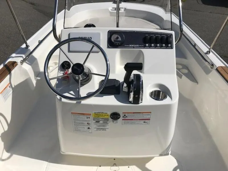 Slide: The Image of 2025 Boston Whaler 170 Montauk boat console with steering wheel and controls. - 14