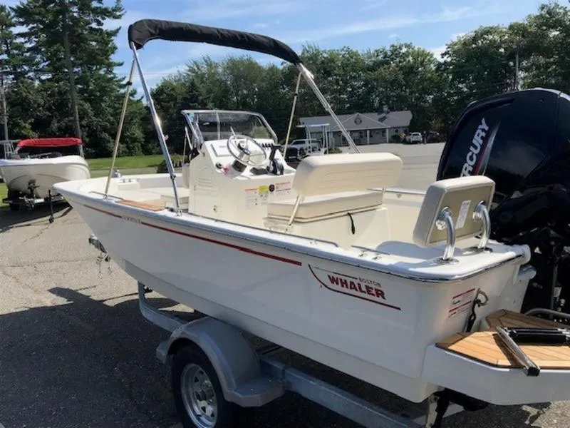 Slide: The Image of 2025 Boston Whaler 170 Montauk boat on trailer, parked outdoors. - 6