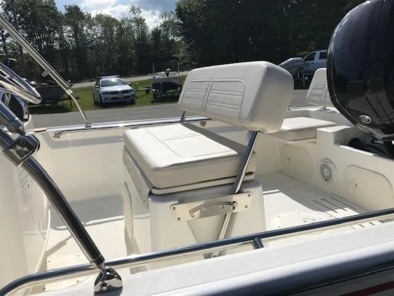 Slide: The Image of 2025 Boston Whaler 170 Montauk boat interior with white seating and motor. - 7