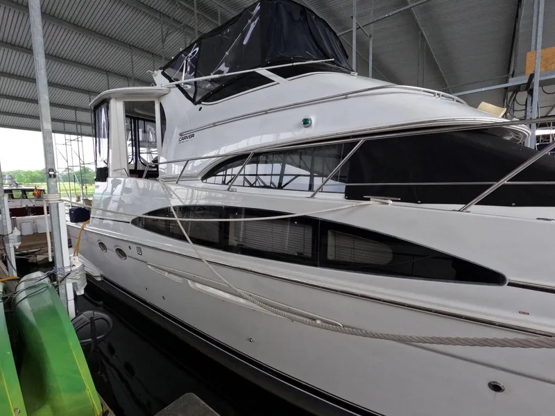 Slide: The Image of 2001 Carver 444 Cockpit Motor Yacht docked in a covered marina. - 11