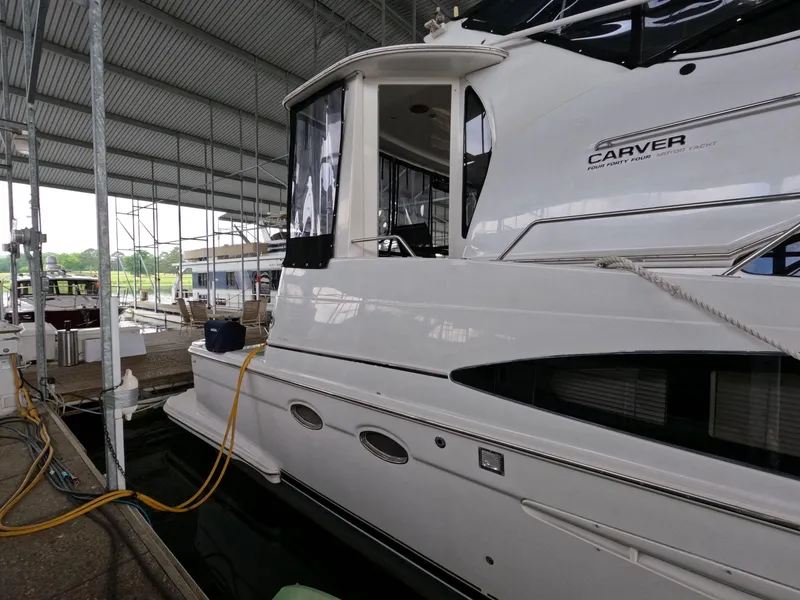 Slide: The Image of 2001 Carver 444 Cockpit Motor Yacht docked in a covered marina. - 12