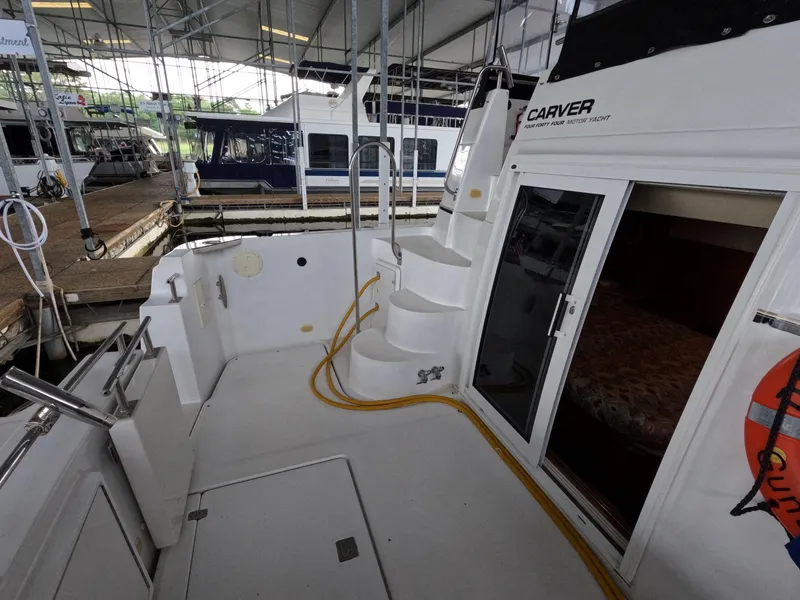 Slide: The Image of 2001 Carver 444 Cockpit Motor Yacht interior view with stairs and docked boats. - 20