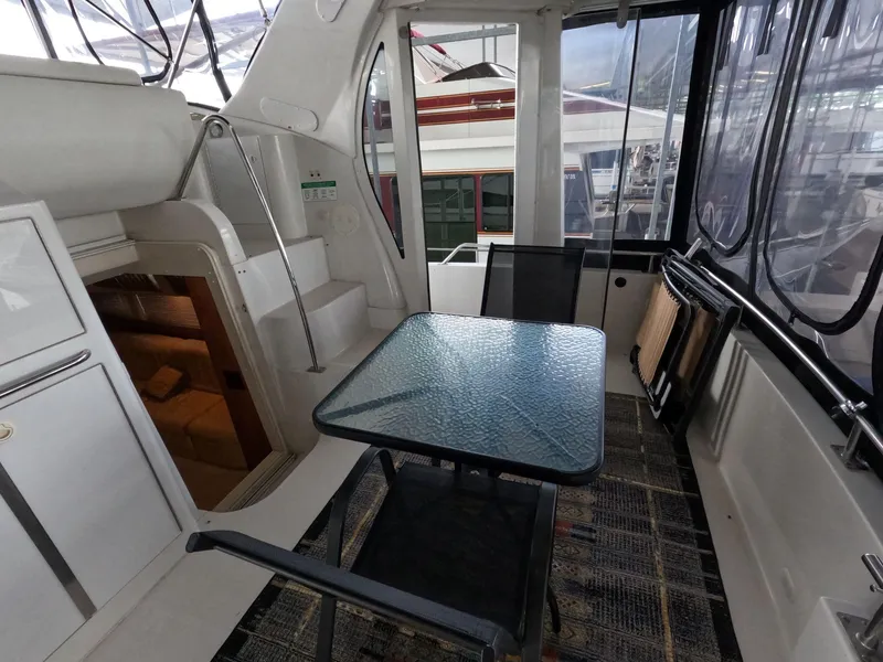 Slide: The Image of 2001 Carver 444 Cockpit Motor Yacht interior with glass table and seating. - 21