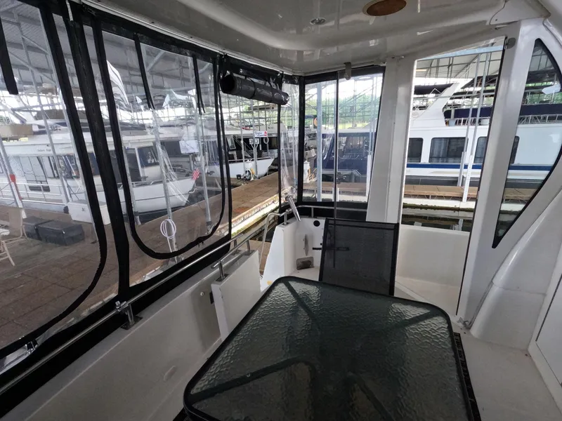 Slide: The Image of 2001 Carver 444 Cockpit Motor Yacht interior with glass table and marina view. - 22