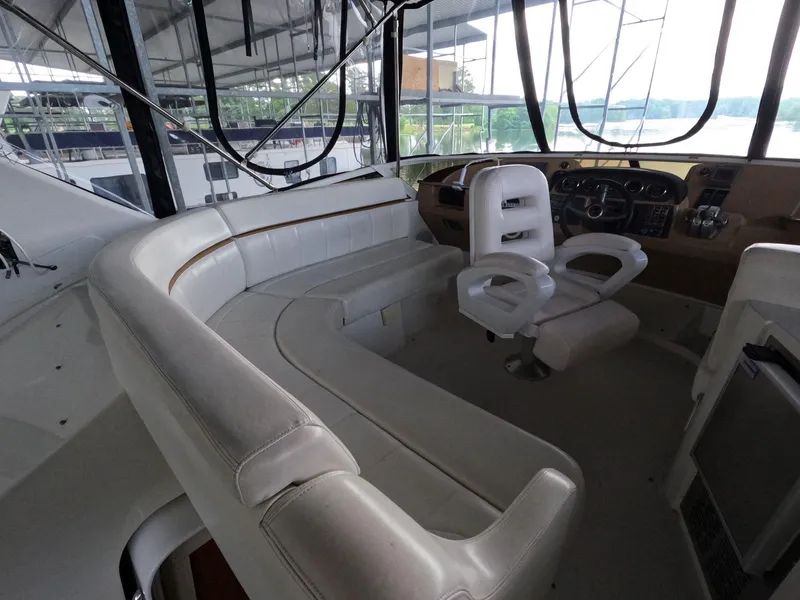 Slide: The Image of 2001 Carver 444 Cockpit Motor Yacht interior with white seating and helm station. - 24