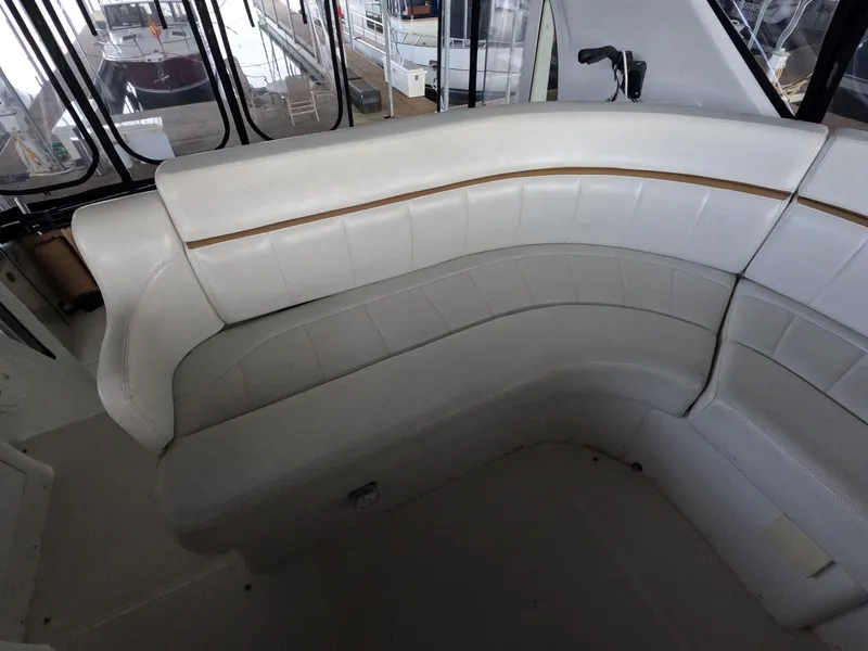 Slide: The Image of 2001 Carver 444 Cockpit Motor Yacht interior seating area with white leather upholstery. - 26