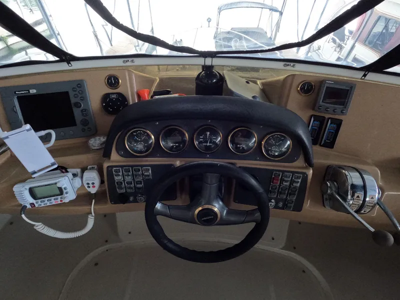 Slide: The Image of 2001 Carver 444 Cockpit Motor Yacht helm with steering wheel, gauges, and navigation equipment. - 31