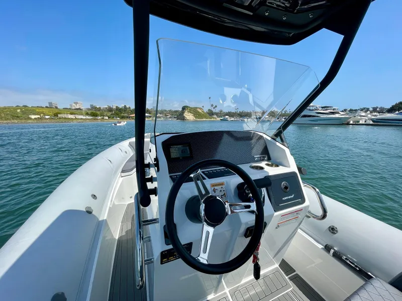 Slide: The Image of 2024 Northstar Orion 8 boat cockpit with steering wheel and control panel on the water. - 19