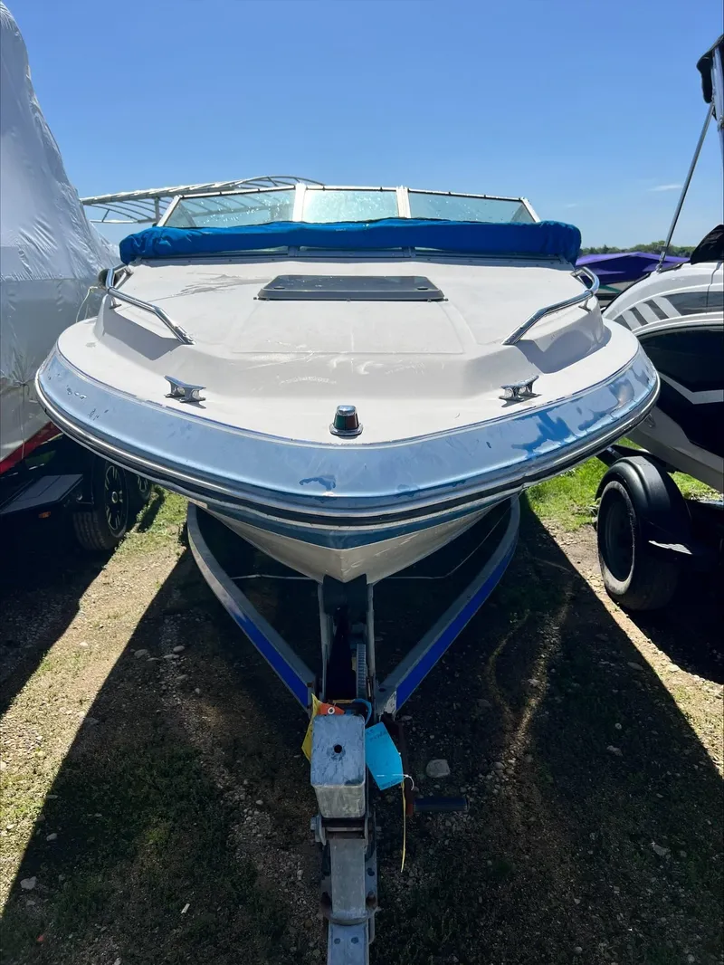 Slide: The Image of 1988 Sea Ray Sierra boat on trailer, parked outdoors under clear sky. - 12