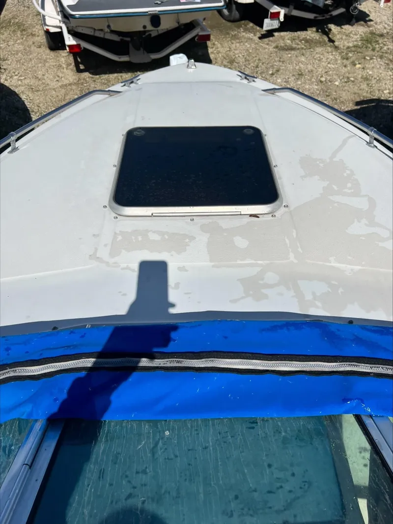 Slide: The Image of 1988 Sea Ray Sierra boat deck with hatch, blue cover, and shadow. - 13