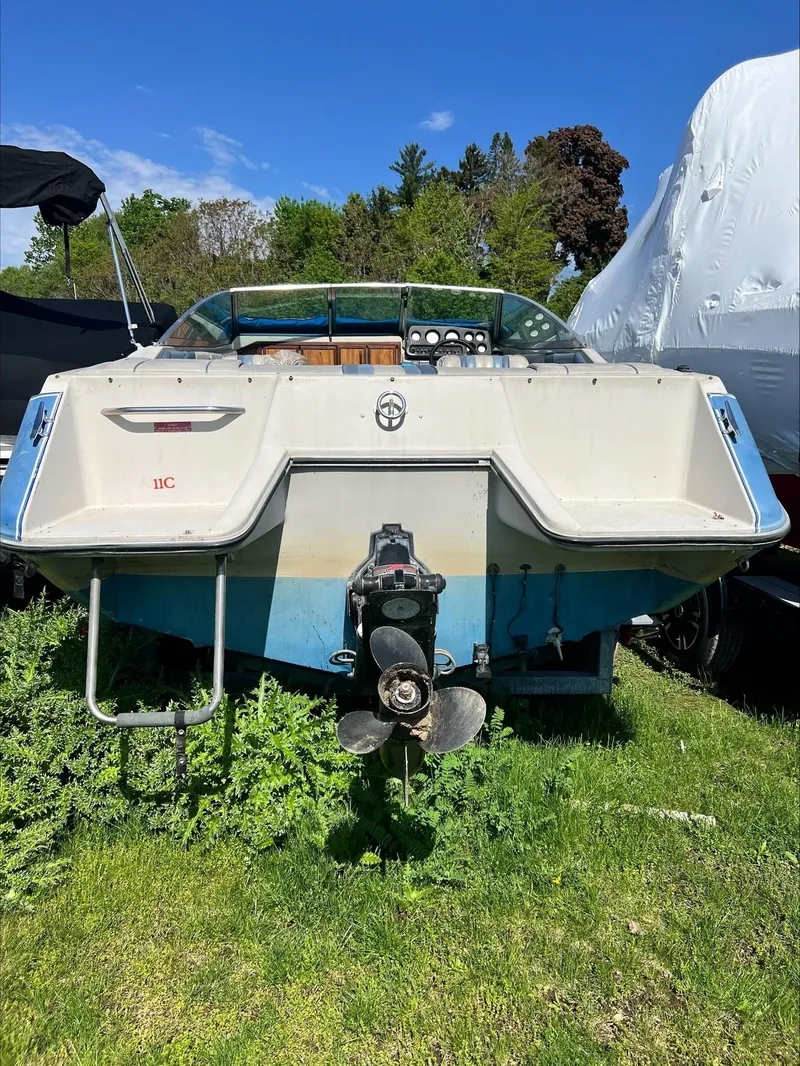 Slide: The Image of 1988 Sea Ray Sierra boat, rear view, on grass with clear sky background. - 3