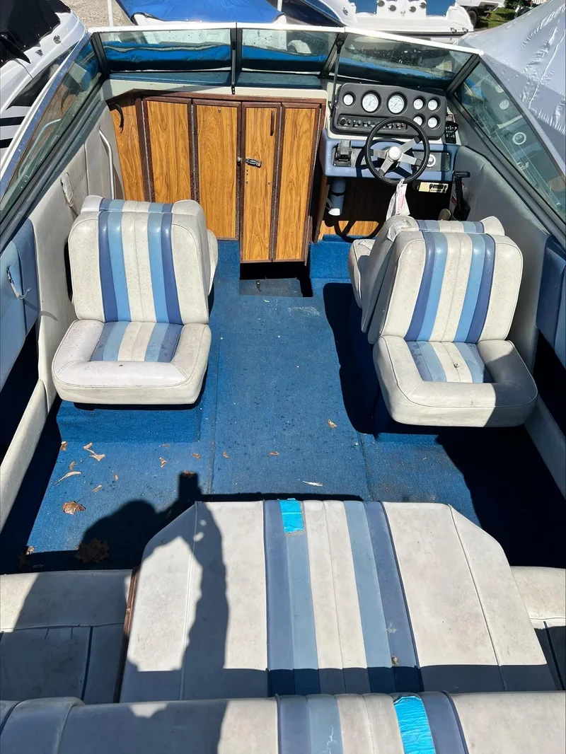 Slide: The Image of Interior of a 1988 Sea Ray Sierra boat with blue and white striped seats. - 4