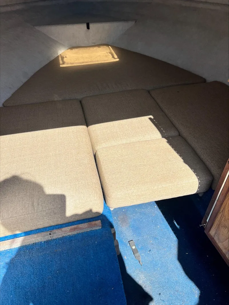 Slide: The Image of Interior cabin of 1988 Sea Ray Sierra boat with beige cushions and blue carpet. - 6