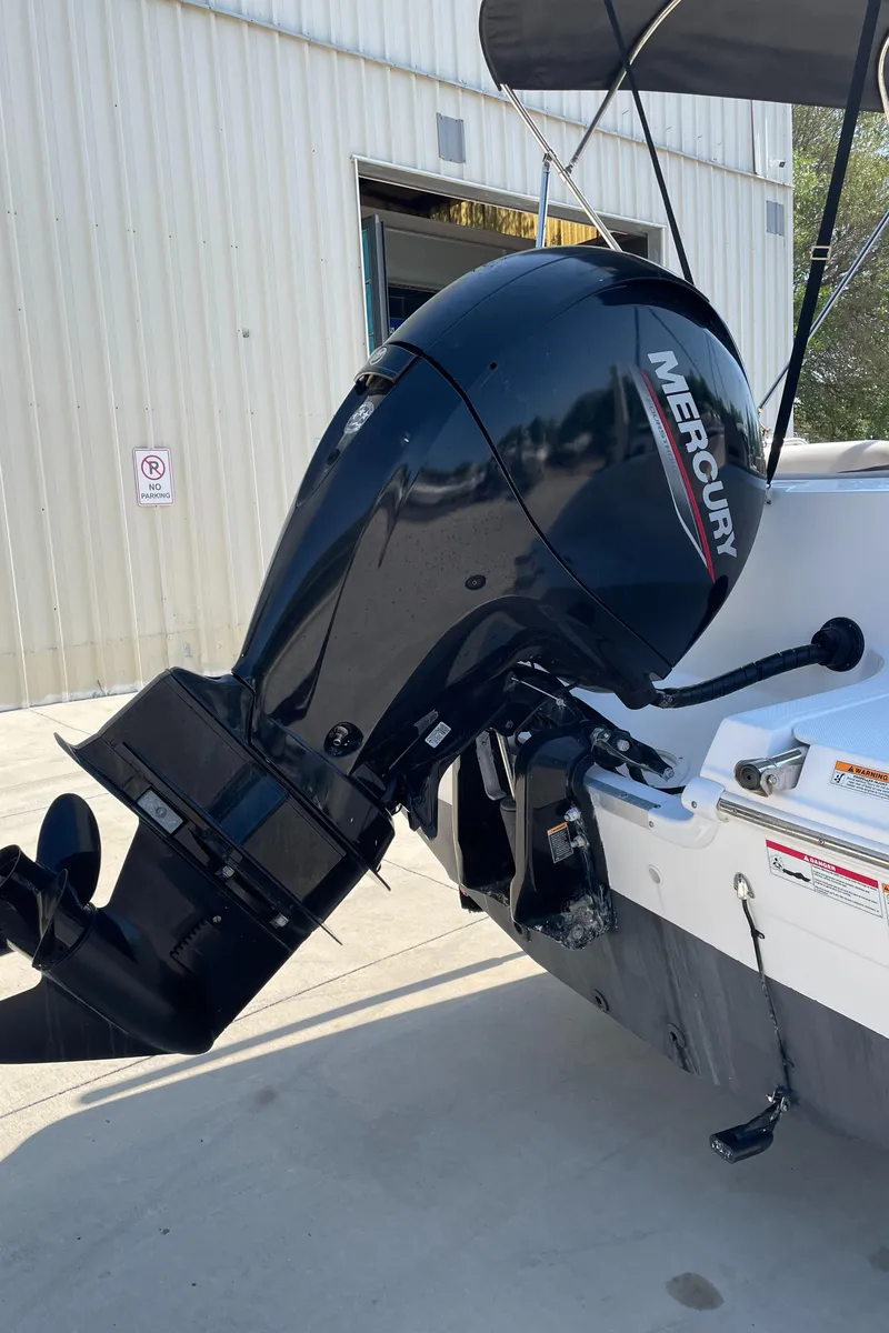 Slide: The Image of 2021 Hurricane SunDeck Sport 201 OB with Mercury outboard motor, docked near a warehouse. - 10