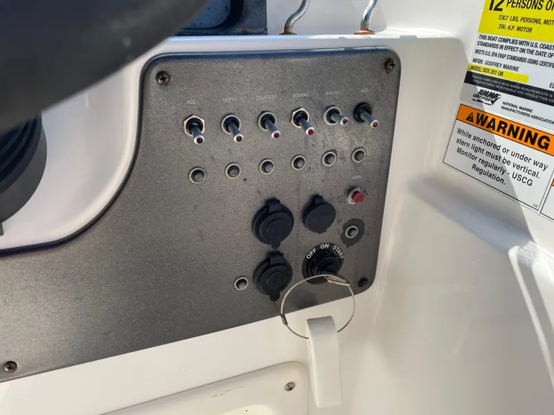 Slide: The Image of Control panel of 2021 Hurricane SunDeck Sport 201 OB boat with switches and warning label. - 23