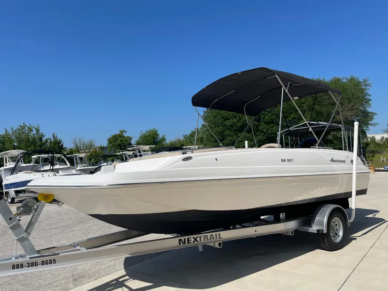 Slide: The Image of 2021 Hurricane SunDeck Sport 201 OB boat on trailer, with canopy, in outdoor setting. - 4