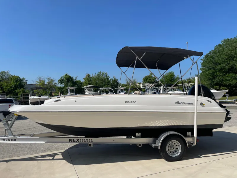 Slide: The Image of 2021 Hurricane SunDeck Sport 201 OB boat on trailer, with canopy, in outdoor setting. - 5