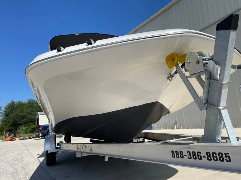 Slide: The Image of 2021 Hurricane SunDeck Sport 201 OB boat on trailer, parked outdoors under clear blue sky. - 8