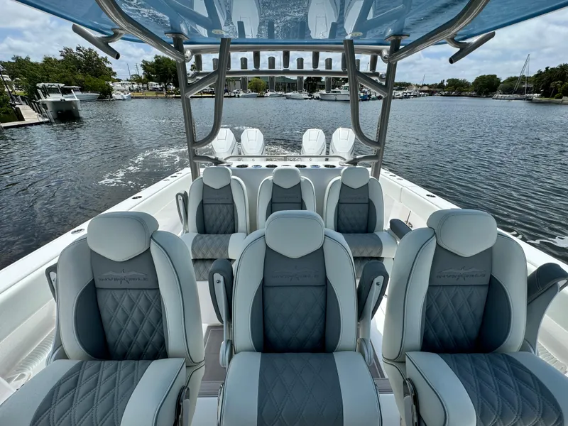 Slide: The Image of 2024 Invincible 40 Catamaran with luxurious seating on a serene waterway. - 12