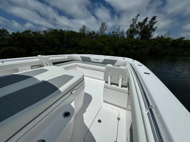 Slide: The Image of 2024 Invincible 40 Catamaran boat interior with cushioned seating and storage compartments. - 21