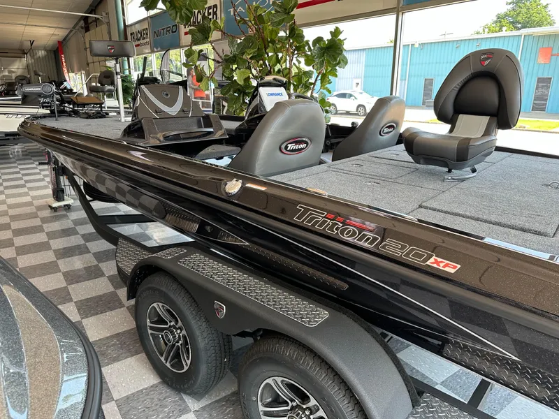 Slide: The Image of 2024 Triton 20XP Patriot boat displayed in showroom, featuring sleek design and modern seating. - 2