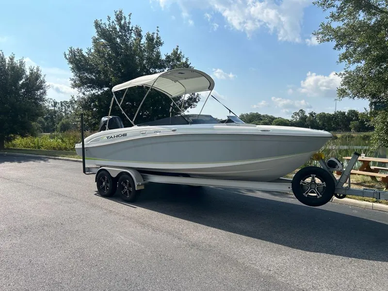 The Image of 2023 Tahoe 210 S Limited boat on trailer, parked near a lake. - 0