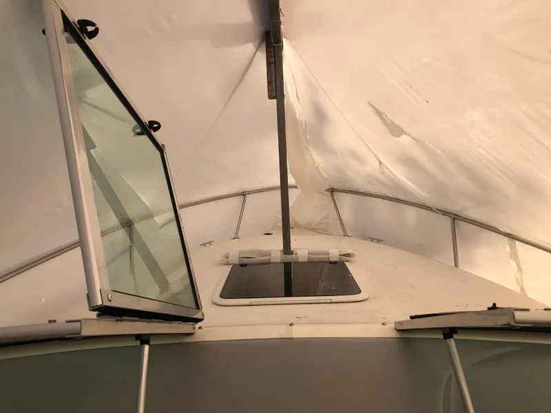 Slide: The Image of 1994 Sea Ray Overnighter boat under cover with open hatch and windows. - 12