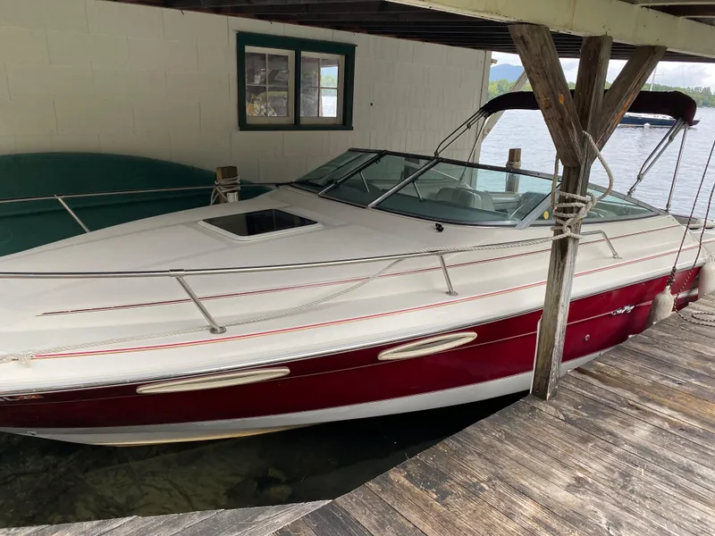 Slide: The Image of 1994 Sea Ray Overnighter boat docked under a wooden shelter. - 2