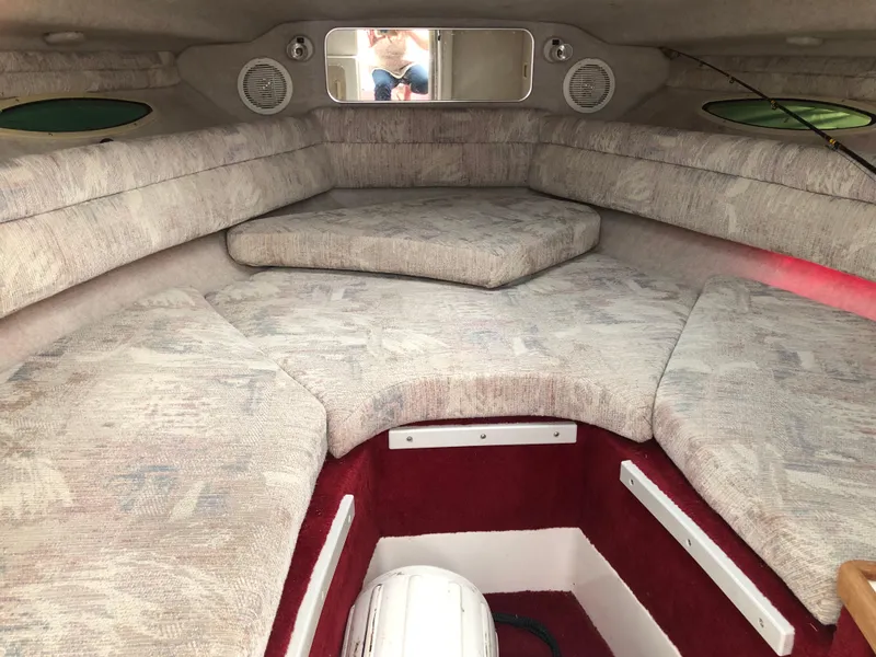 Slide: The Image of 1994 Sea Ray Overnighter cabin interior with cushioned seating and red carpet accents. - 24