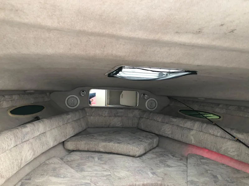 Slide: The Image of Interior cabin of a 1994 Sea Ray Overnighter boat with cushioned seating and a skylight. - 27