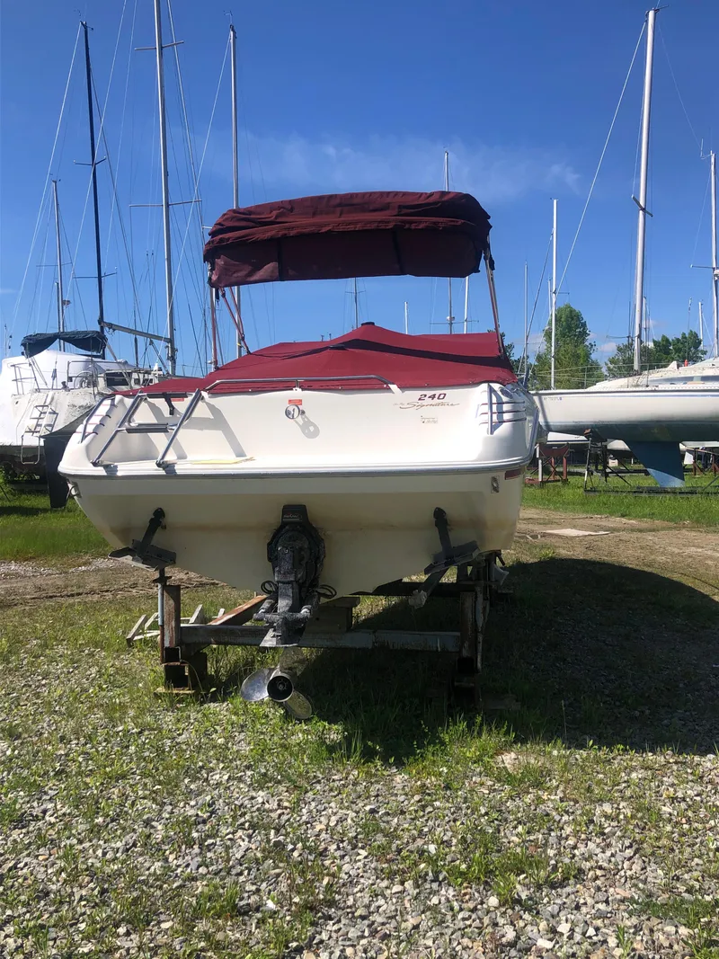 Slide: The Image of 1994 Sea Ray Overnighter boat with red canopy, parked on gravel. - 31