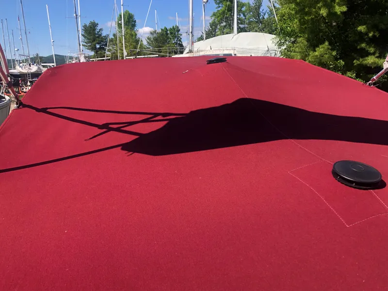 Slide: The Image of Red cover on 1994 Sea Ray Overnighter boat, docked with trees and masts in background. - 34