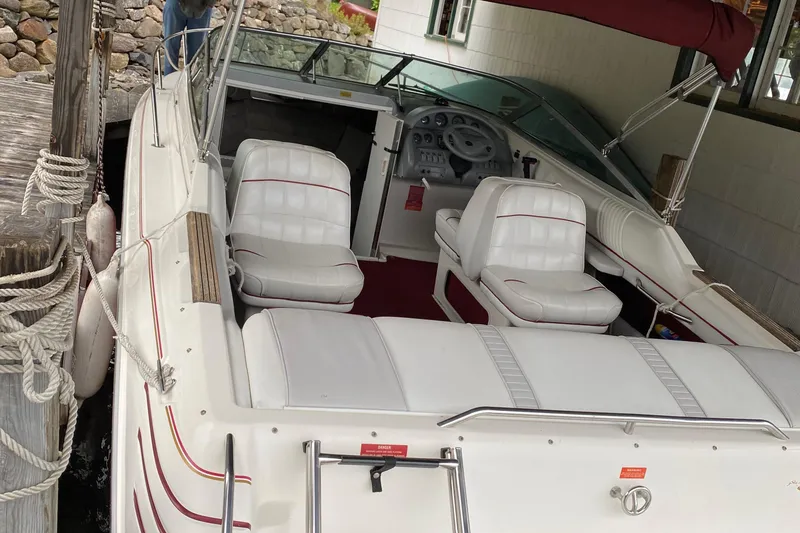 Slide: The Image of 1994 Sea Ray Overnighter boat with white seating, docked in a covered area. - 5