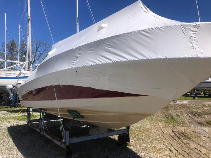 Slide: The Image of 1994 Sea Ray Overnighter boat covered and stored on a trailer outdoors. - 6