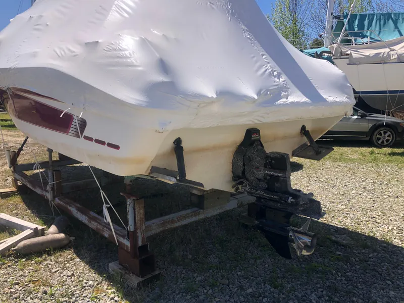 Slide: The Image of 1994 Sea Ray Overnighter boat covered and stored on a trailer outdoors. - 7