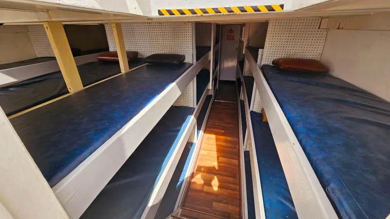 Slide: The Image of 1958 Ditmar & Donaldson sport boat interior with multiple bunk beds and wooden flooring. - 10
