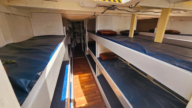 Slide: The Image of 1958 Ditmar & Donaldson Sport Boat interior with multiple bunk beds and wooden flooring. - 11