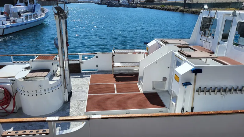 Slide: The Image of 1958 Ditmar & Donaldson sport boat deck with wooden flooring, docked by the water. - 4