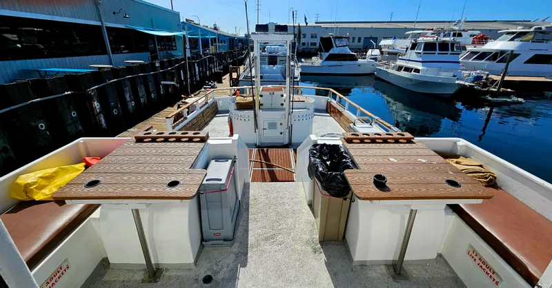 Slide: The Image of 1958 Ditmar & Donaldson sport boat docked, featuring spacious seating and wooden tables. - 6