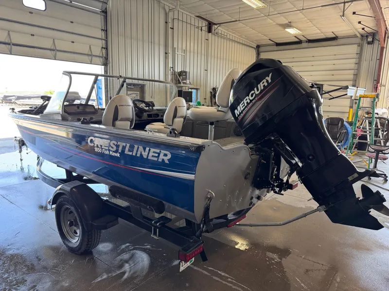 Slide: The Image of 2013 Crestliner 1850 Fish Hawk boat with Mercury engine in a garage setting. - 3