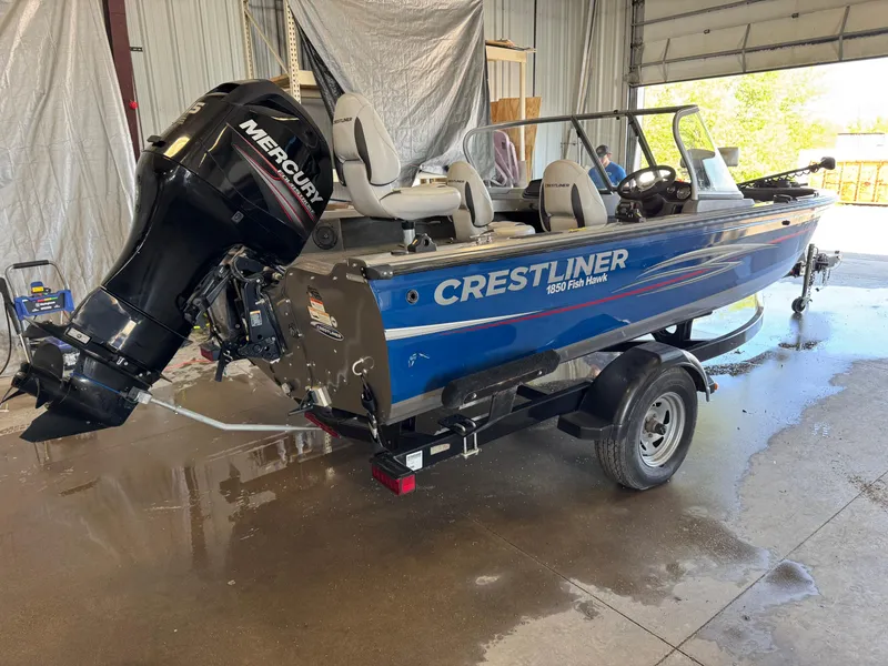 Slide: The Image of 2013 Crestliner 1850 Fish Hawk boat with Mercury outboard motor in a garage. - 5