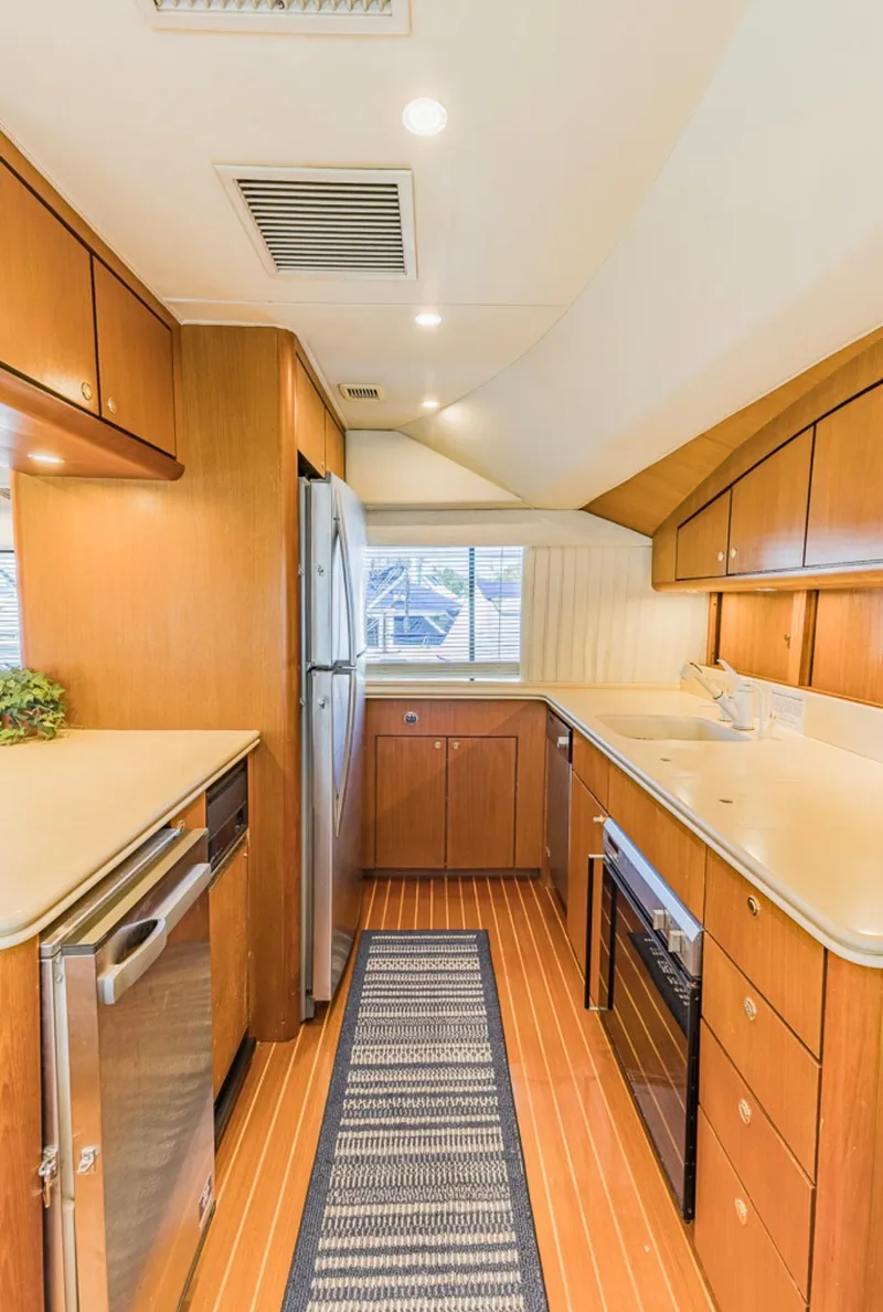 Slide: The Image of 1999 Ocean Yachts 60 Convertible kitchen with wood cabinetry and modern appliances. - 11