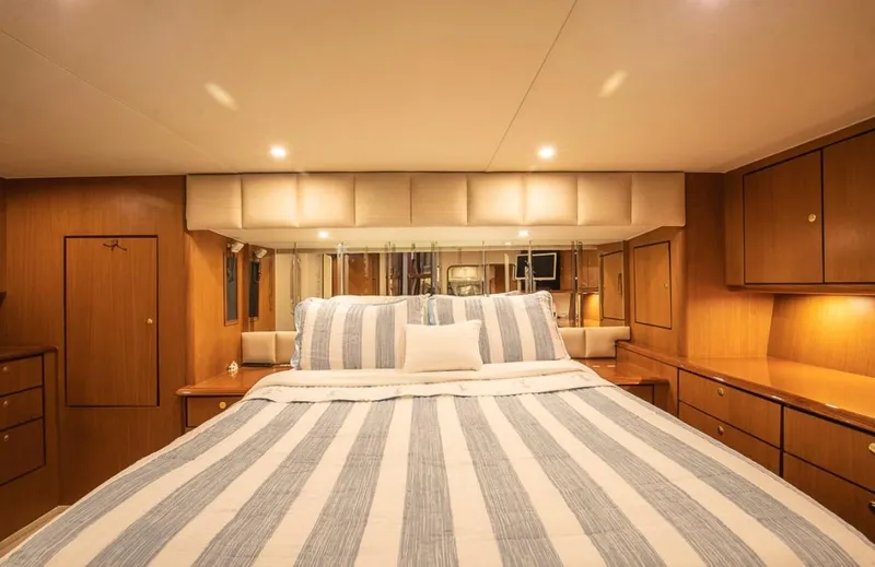 Slide: The Image of Luxurious bedroom interior of 1999 Ocean Yachts 60 Convertible with striped bedding. - 18