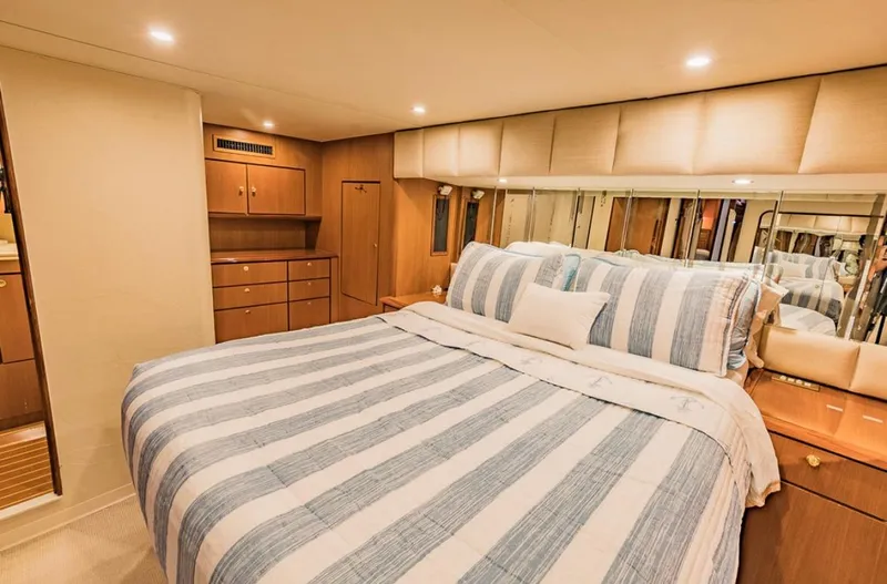 Slide: The Image of Luxurious bedroom interior of 1999 Ocean Yachts 60 Convertible with striped bedding. - 19
