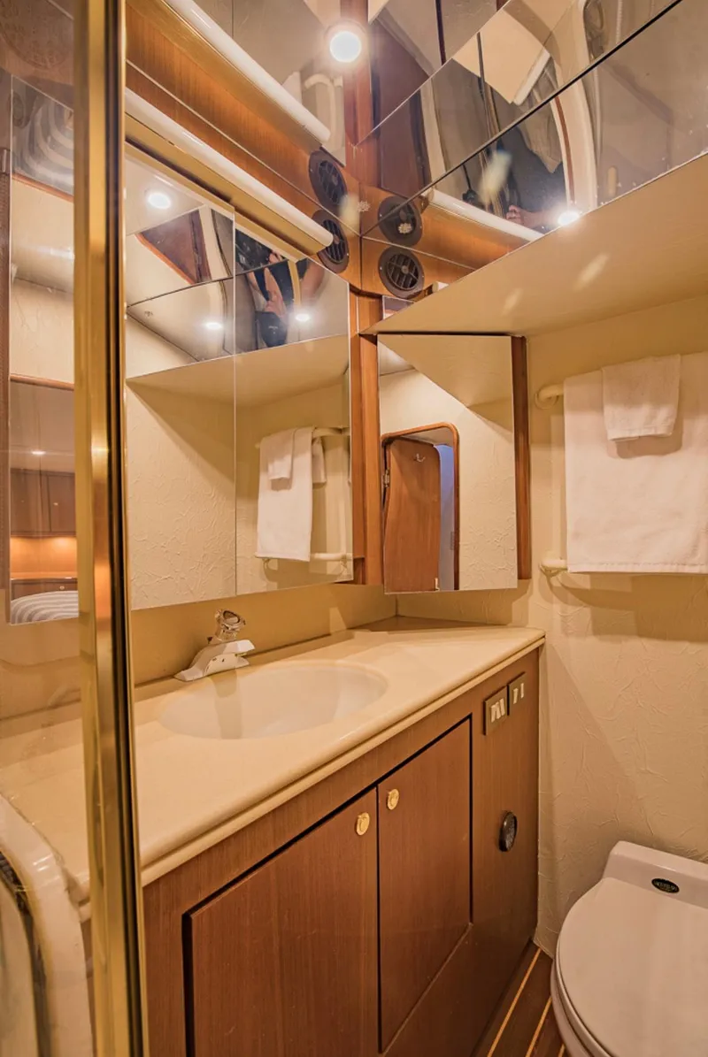 Slide: The Image of Luxurious bathroom in 1999 Ocean Yachts 60 Convertible, featuring elegant wood cabinetry and modern fixtures. - 22
